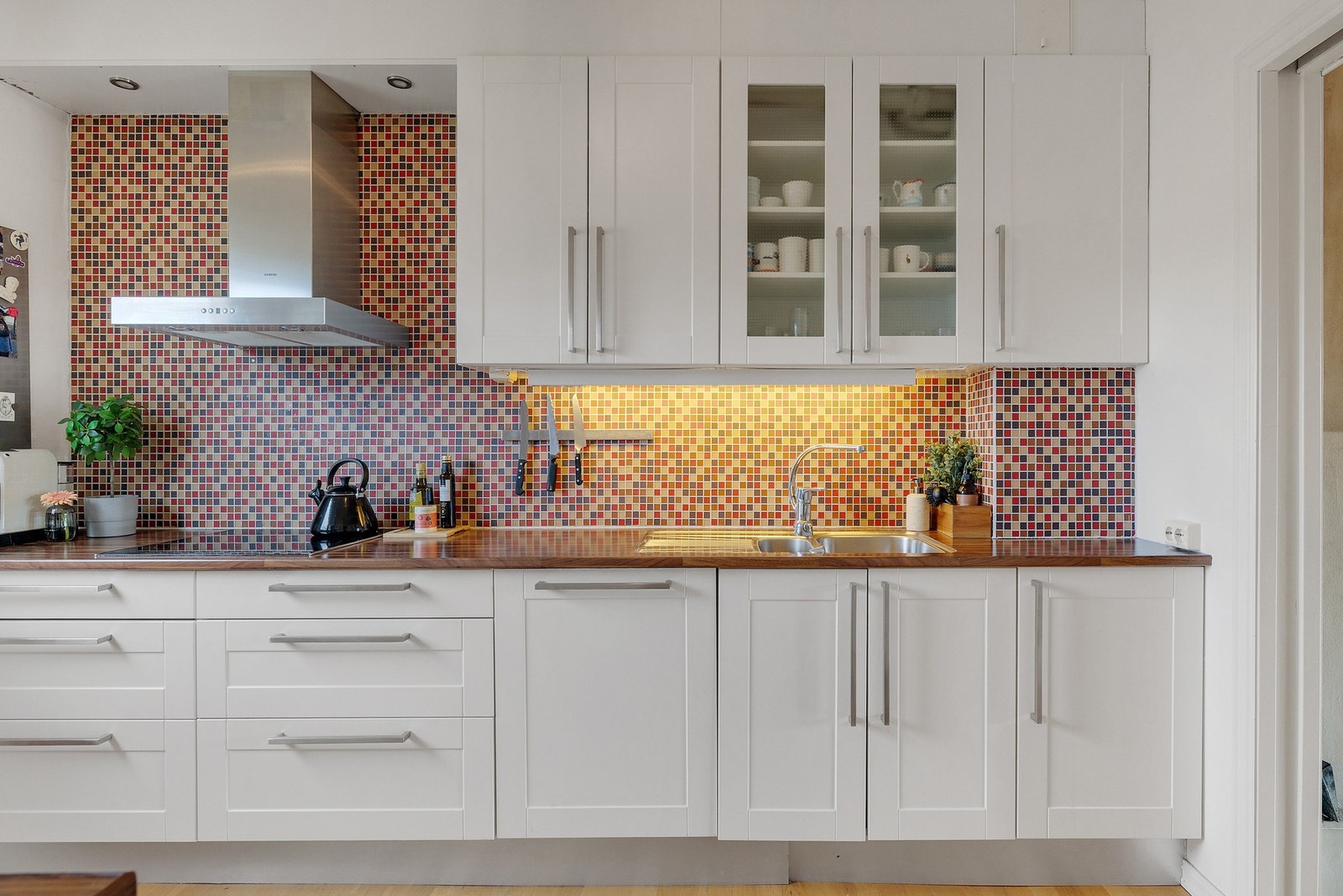 Fin innredning med hvite, profilerte fronter og benkeplate av laminat. Galleribilde