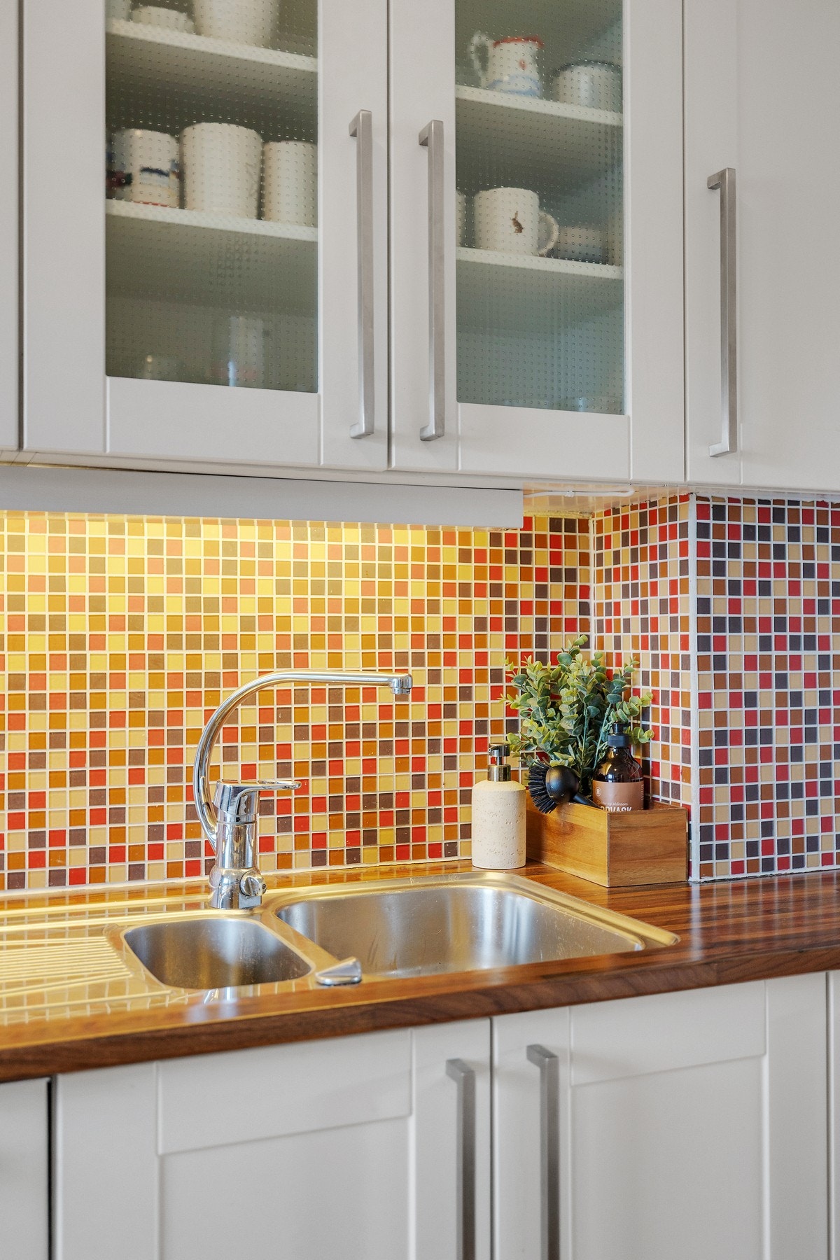 Det er lagt stilige fliser mellom benkeplaten og overskapene. Galleribilde