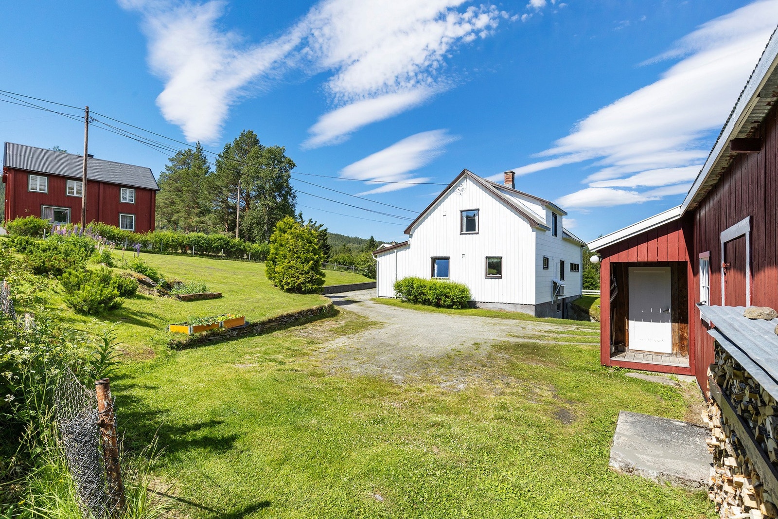 På eiendommen har du en stor garasje og uthus, praktisk for oppbevaring Galleribilde