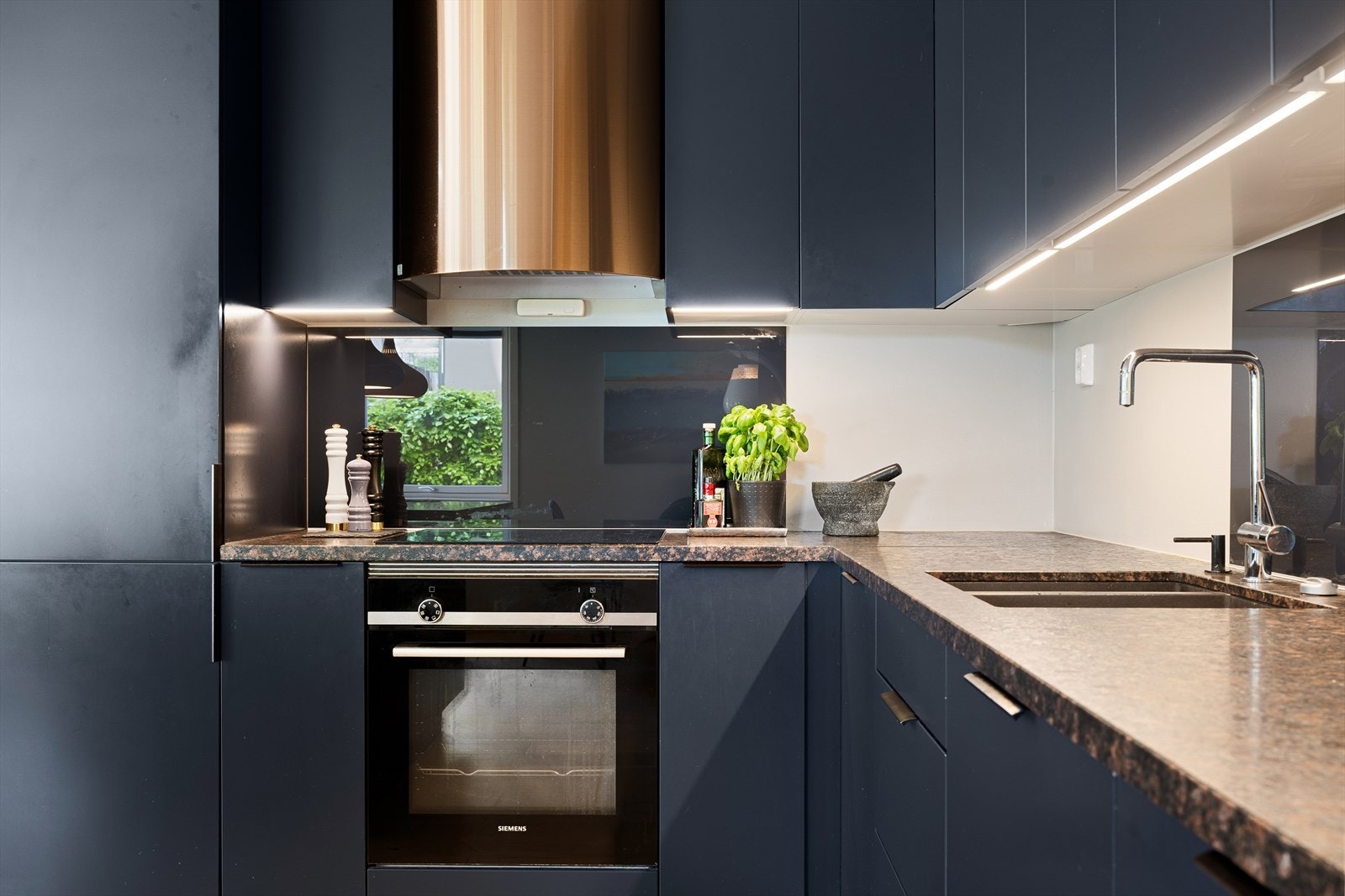 Det er nedfelt oppvaskkum i stål med ettgreps blandebatteri, ventilator med komfyrvakt over platetoppen, og automatisk lekkasjestopper under vask for økt sikkerhet Galleribilde