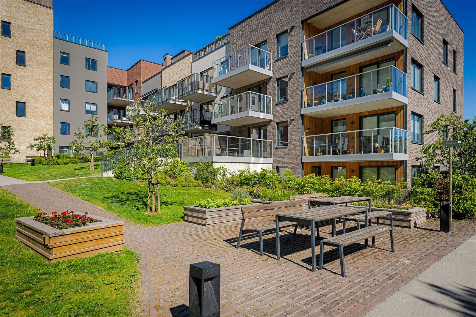 Borettslaget har en godt tilrettelagt bakgård med grøntarealer, prydbusker, gangveier, sittegrupper, sykkelstativ og belysning Galleribilde