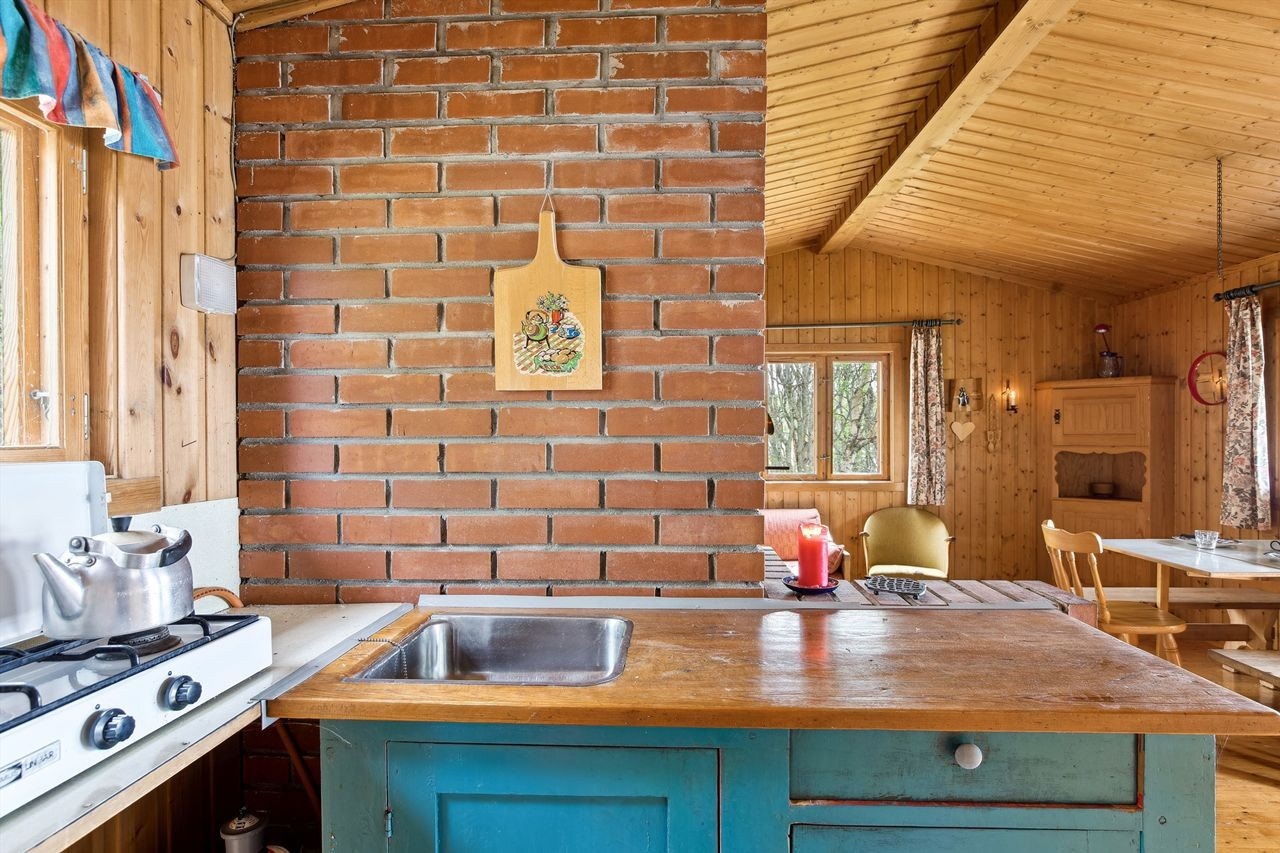 Enkelt innredet kjøkken mede sjarmerende benk fra hyttas opprinnelsesår. Galleribilde