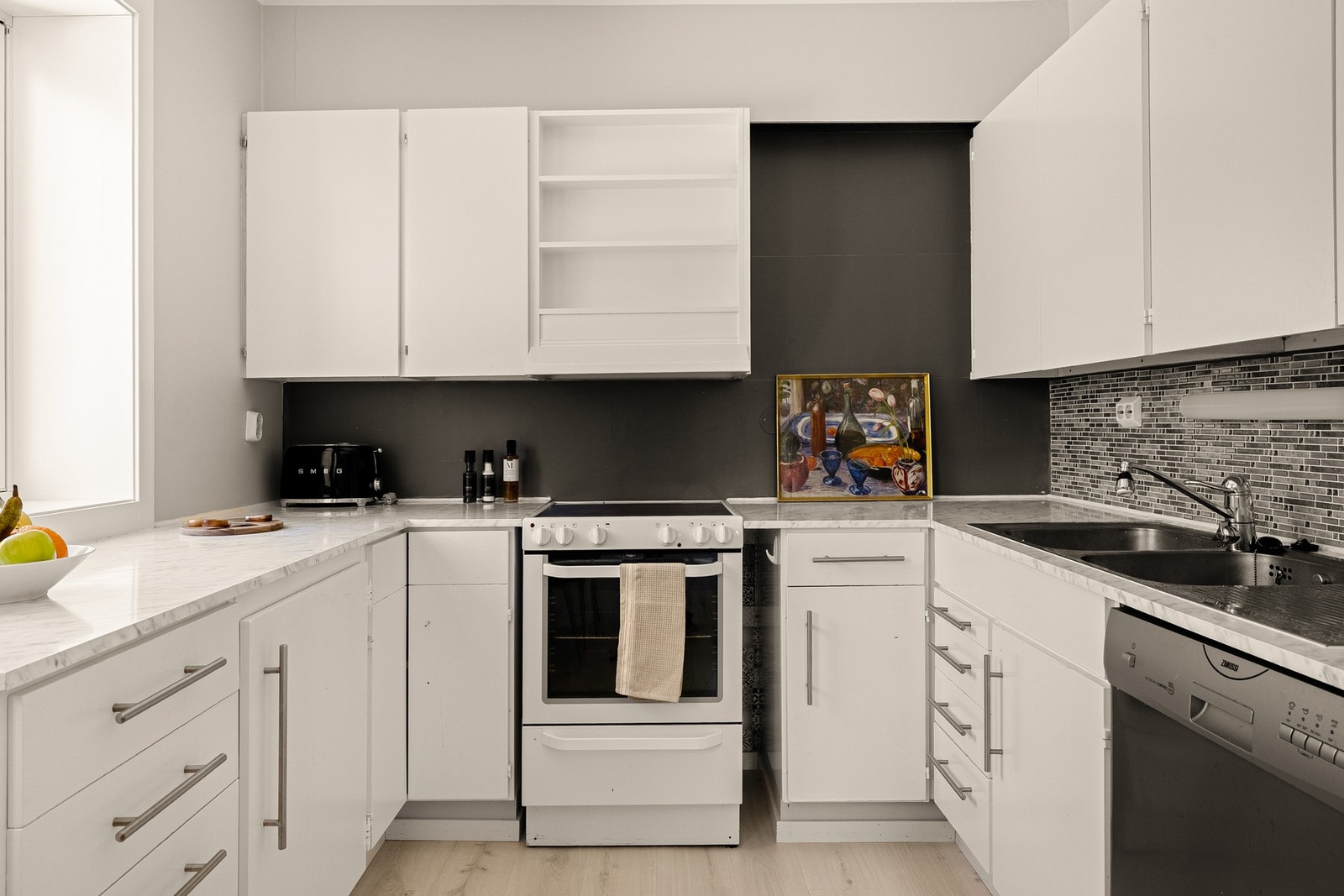 Kjøkkenet inneholder kjøkkeninnredning med slette fronter og laminat benkeplate med nedfelt vask av stål. Galleribilde