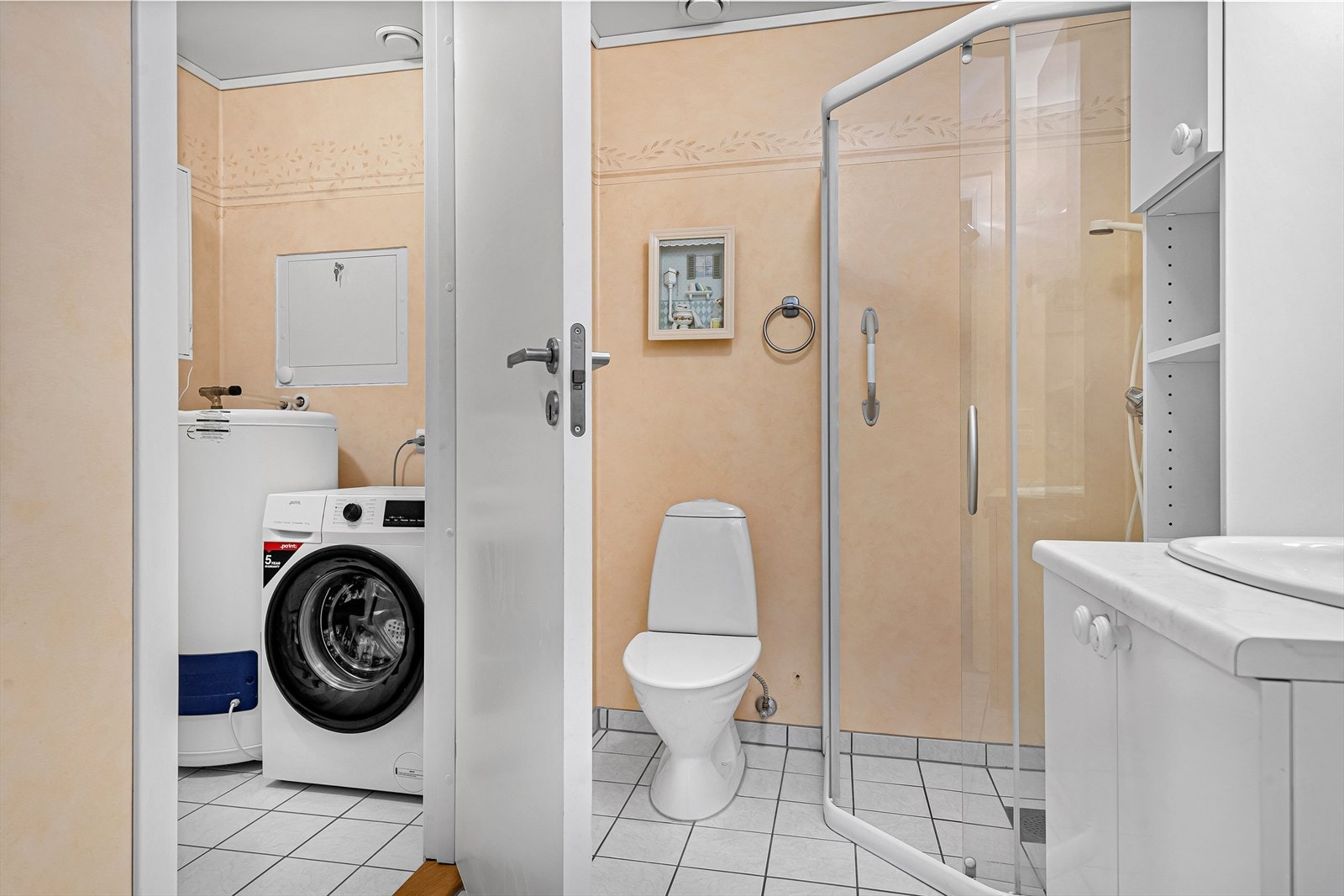 Vegg i vegg med badet er vaskerommet plassert. Galleribilde