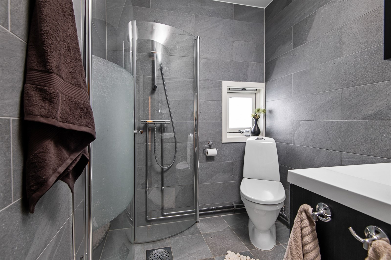 Leiligheten har to fine bad. Begge badene er delikat innredet med mørke fliser på vegg og gulv. Galleribilde
