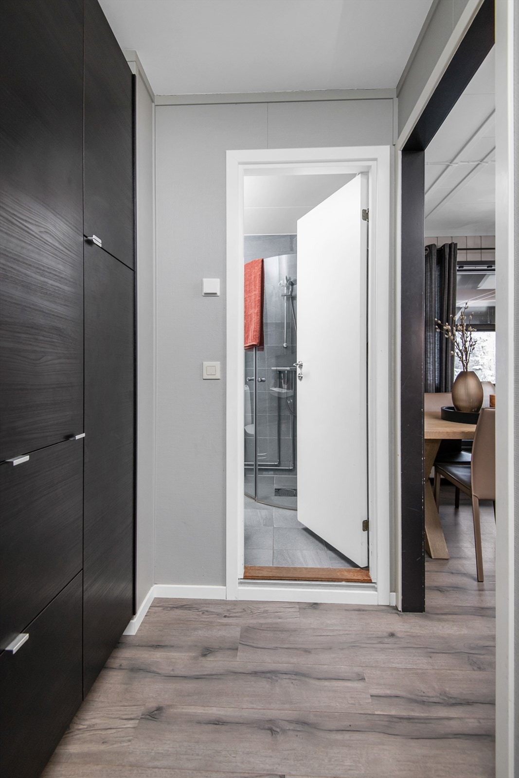 Rommet er godt utnyttet med garderobeskap med sorte fronter og knaggrekke for enkle ytterjakker. Galleribilde