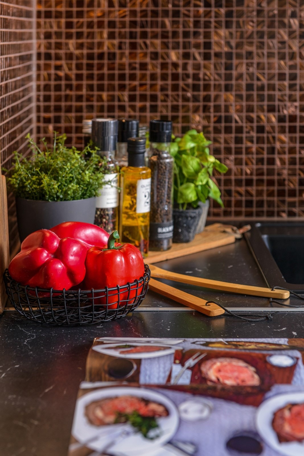 Her er det mosaikkfliser over kjøkkenbenk ved vask og koketopp. Galleribilde