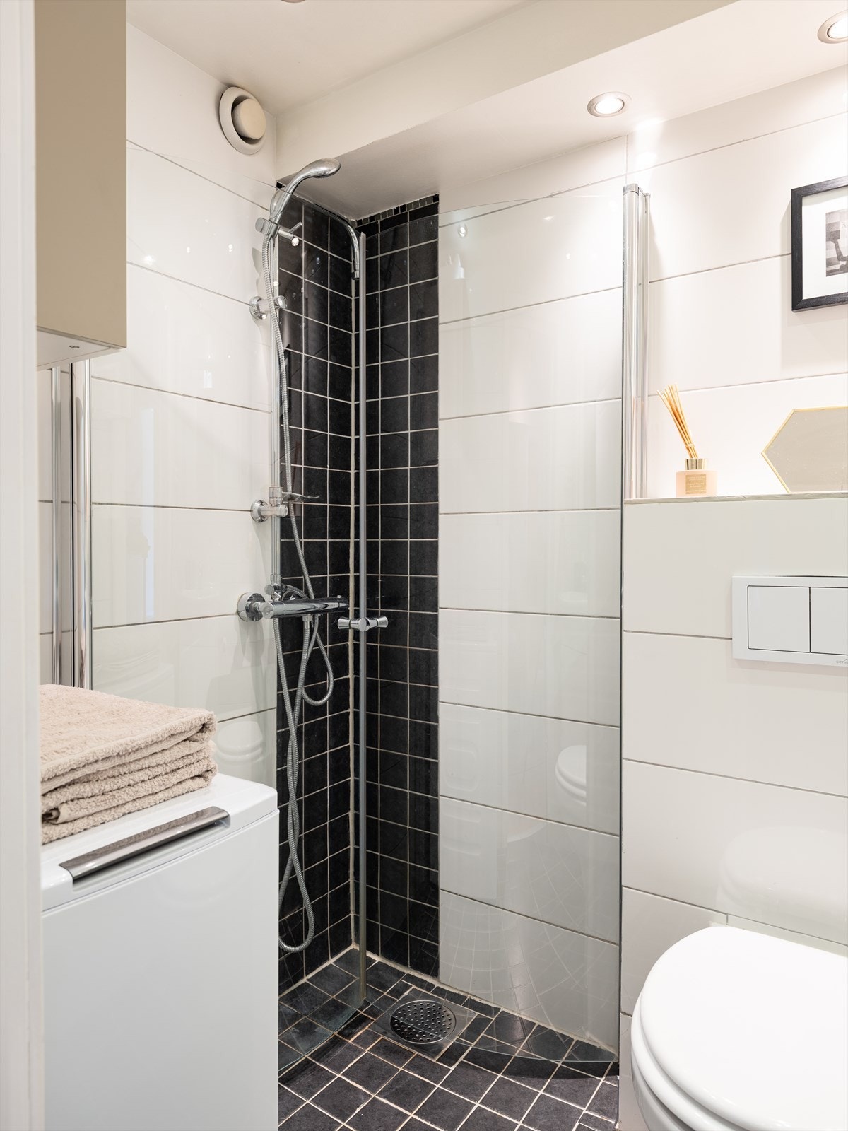 Det er opplegg for vaskemaskin, og dusjhjørnet er buet med innfellbare dører. Galleribilde