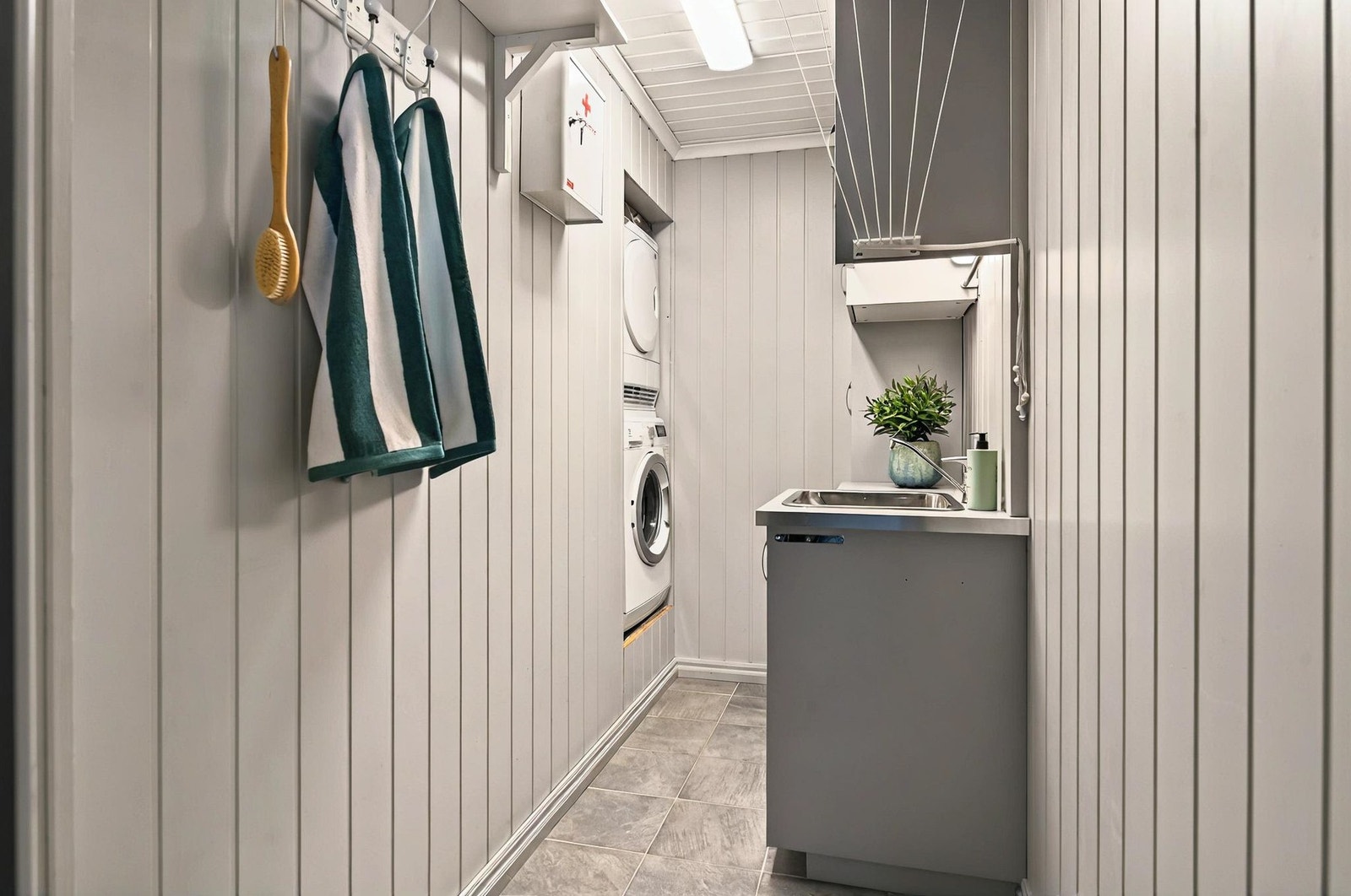 Praktisk vaskerom med god plass til tørk av klær og enkel organisering for et ryddig og funksjonelt rom Galleribilde