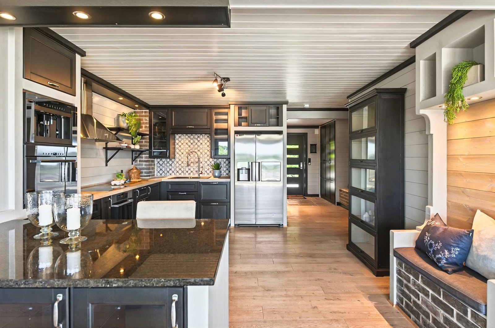 Den svarte kjøkkeninnredningen harmonerer med de øvrige mørke detaljene og gir boligen et helhetlig og moderne preg Galleribilde