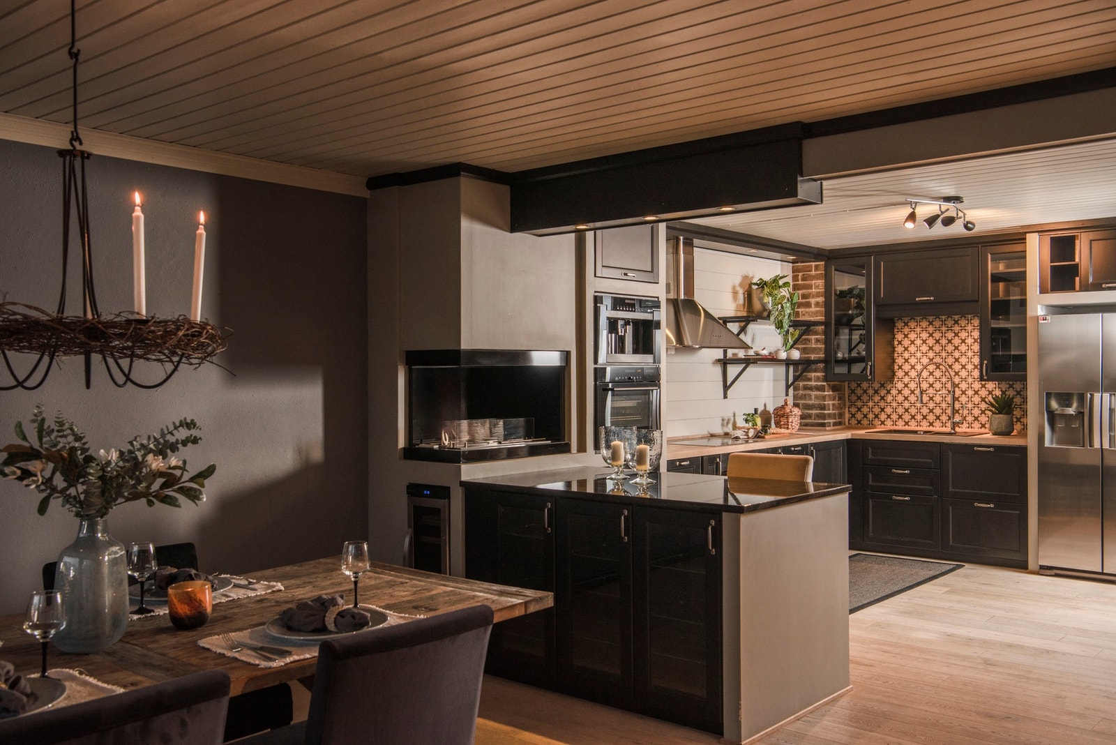 Rommet er utformet slik at det skapes et naturlig skille mellom kjøkken og stue, samtidig som den åpne følelsen bevares Galleribilde