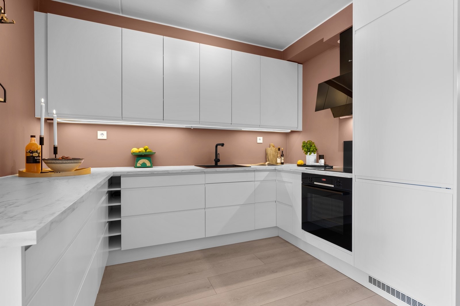 Innredningen har hvite glatte fronter med gripelist, kombinert med lys laminat benkeplate Galleribilde