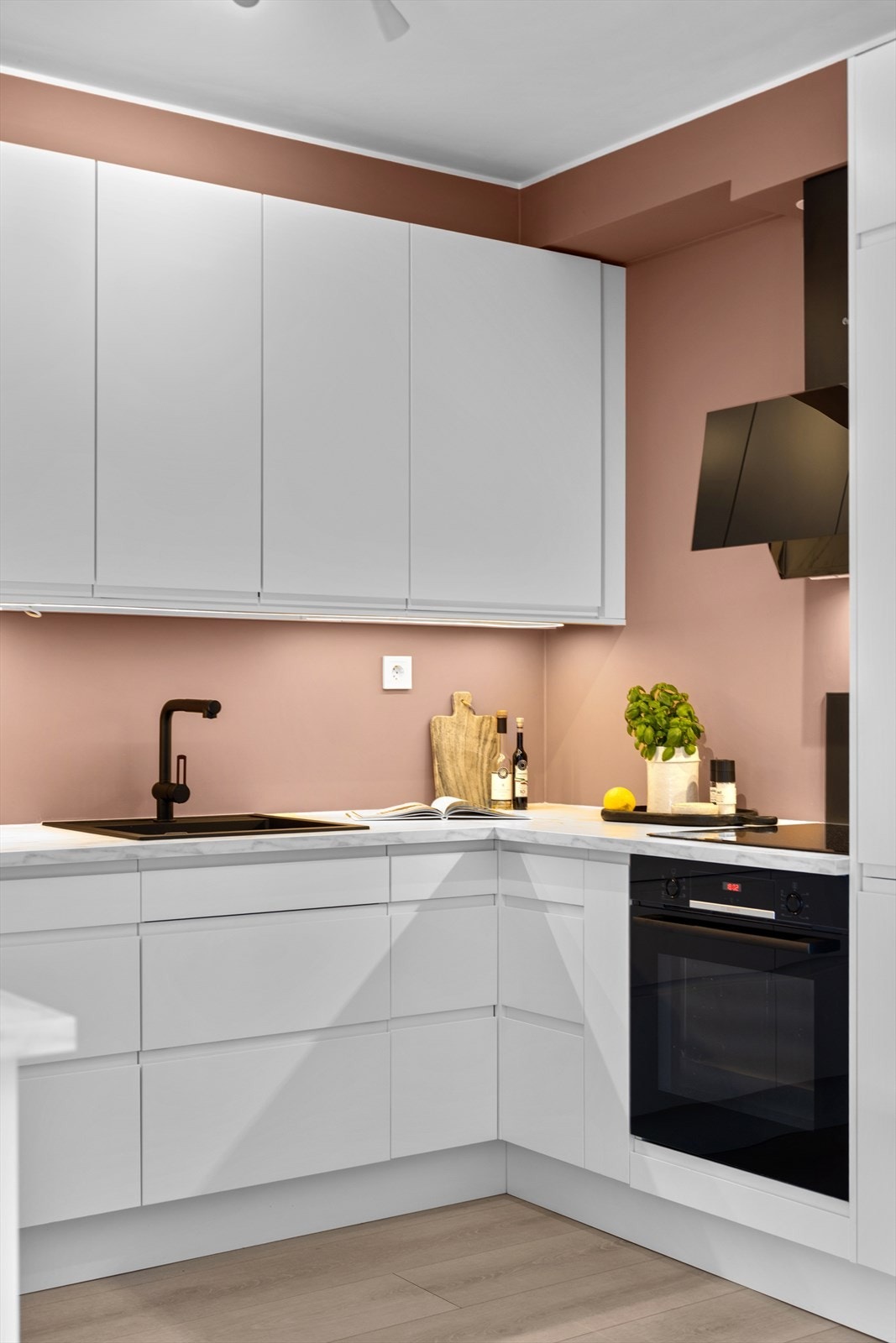 Kjøkkenet er utstyrt med nedfelt vaskekum, belysning over benkeplaten og helintegrerte hvitevarer Galleribilde