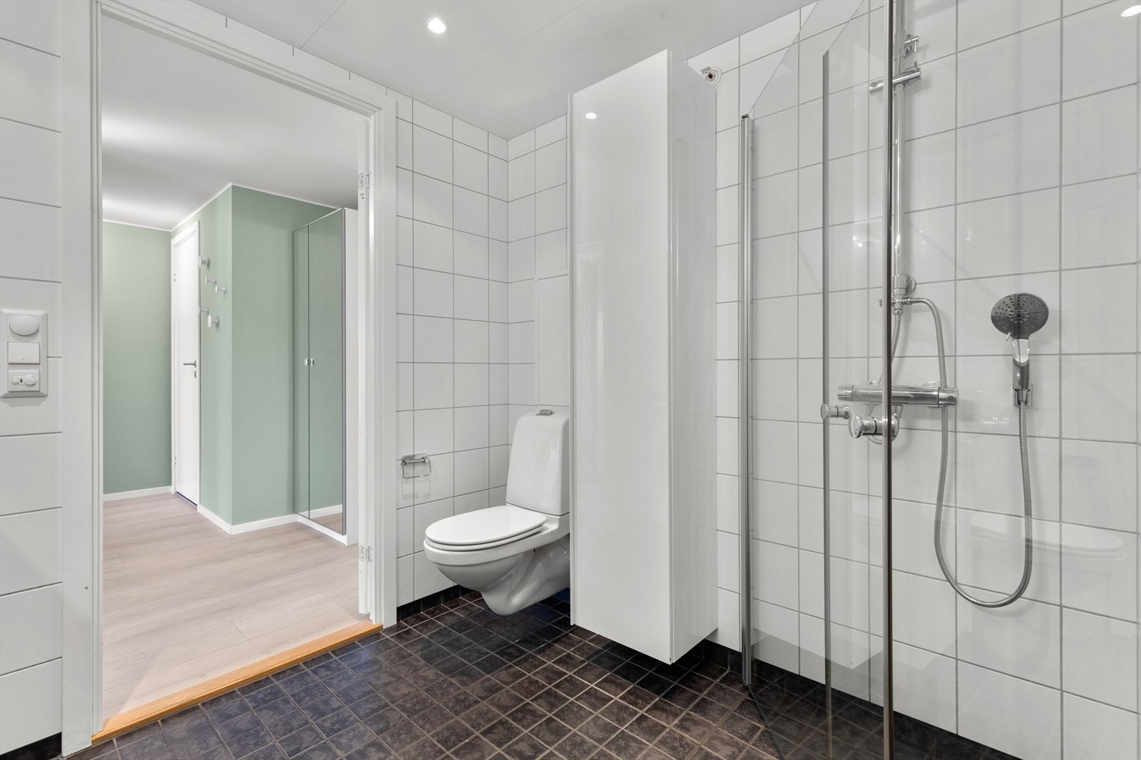 Det er vegghengt toalett og dusjhjørne med glass vegger Galleribilde