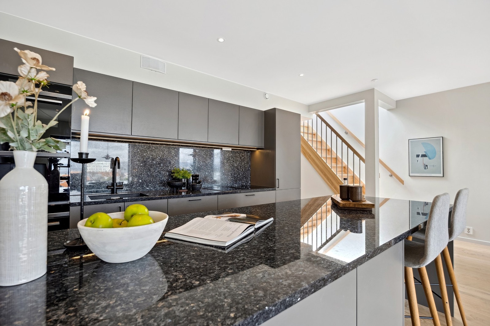 En praktisk kjøkkenøy legger til rette for sosial matlaging og skaper en naturlig møteplass i rommet. Galleribilde