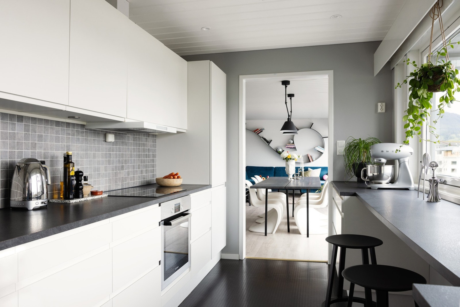 Kjøkkenet har innredning fra danske Aubo (2017) i hvite, slette fronter, laminat benkeplate med flis mot overskap og ventilator. Galleribilde