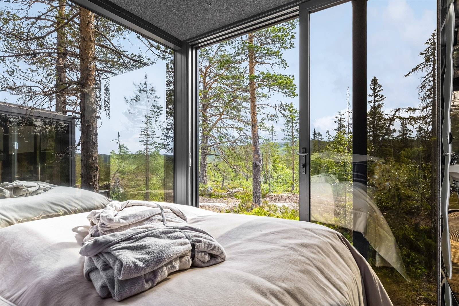 Skyv dørene til side i stuen og visk bort skillet mellom ute og inne - eller inviter den friske luften inn på
soverommet. Panoramadørene gjør overnattingen din til en helt unik og naturnær opplevelse - uansett
vær. Galleribilde