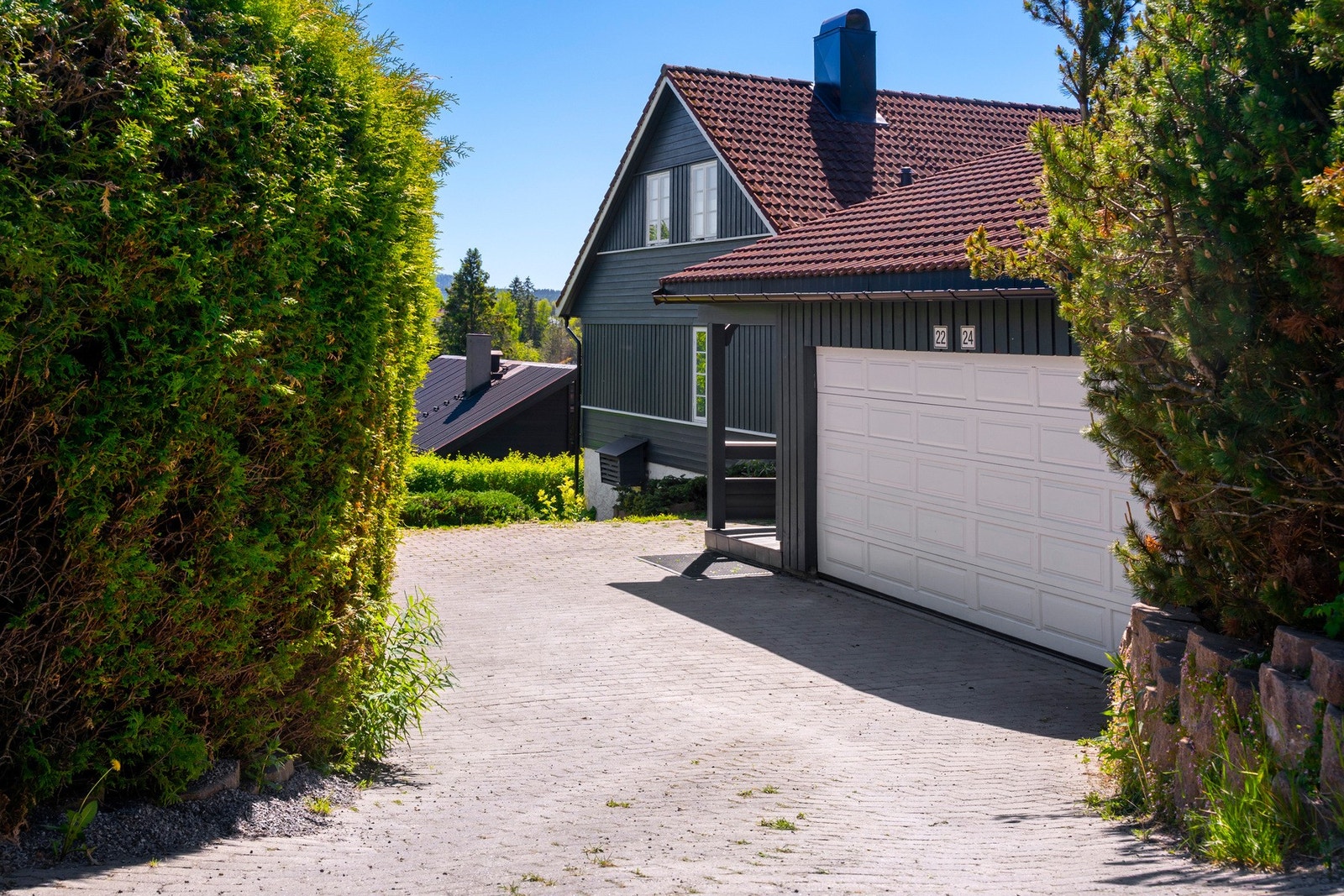 Det er parkering i en tilbygd dobbelgarasje og på gårdsplassen utenfor. Garasjen har dobbel leddport med fjernkontroll og en gangdør. Galleribilde