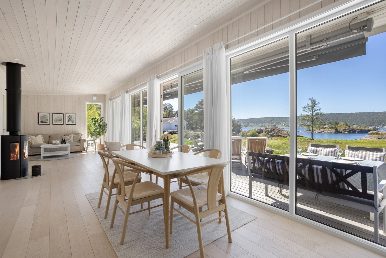 Romslig stue med store vindusflater med sjøen. Galleribilde