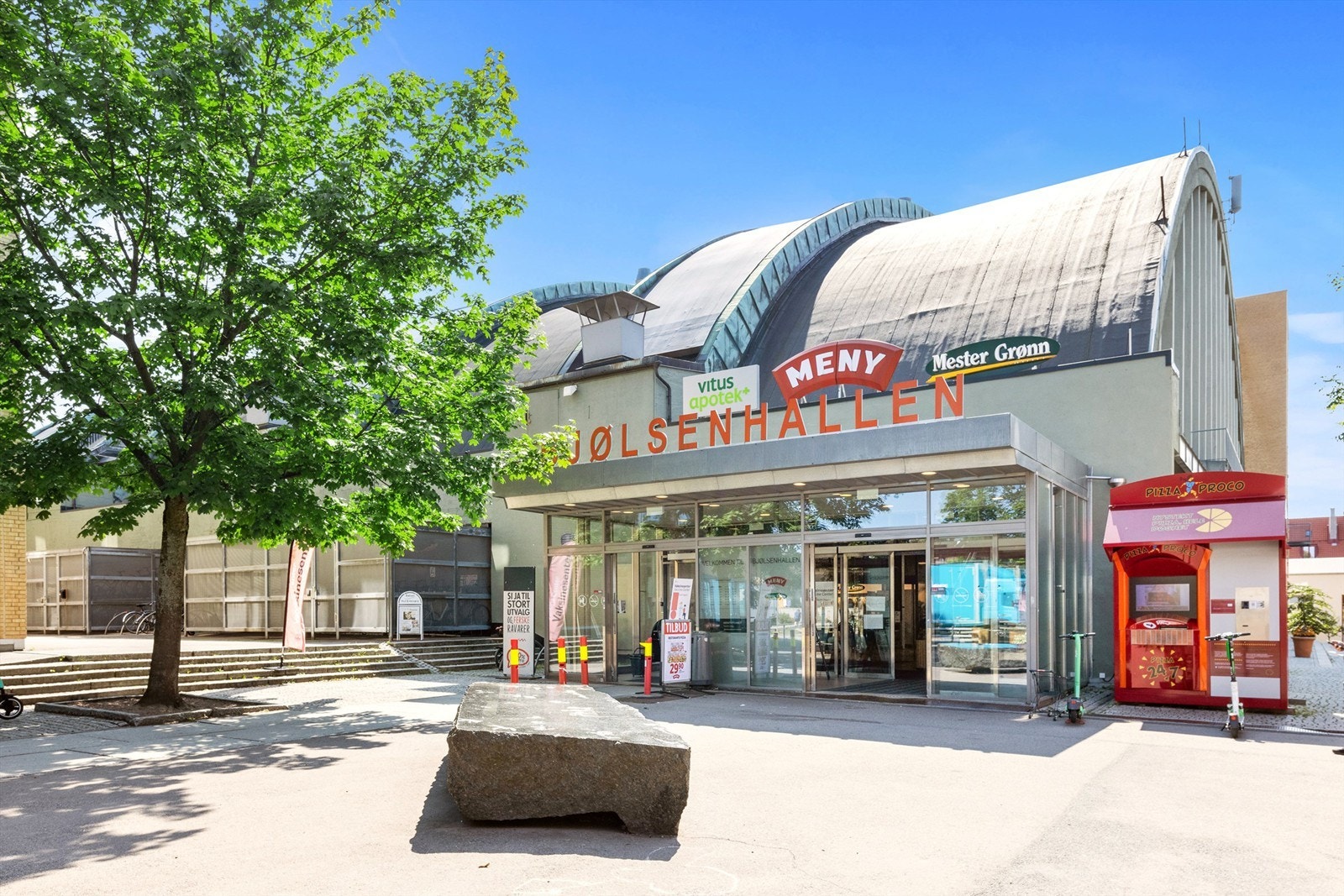 Vis a vis leiligheten har du Bjølsenhallen med blant annet frisørsalong, blomsterbutikk, apotek og Meny Galleribilde