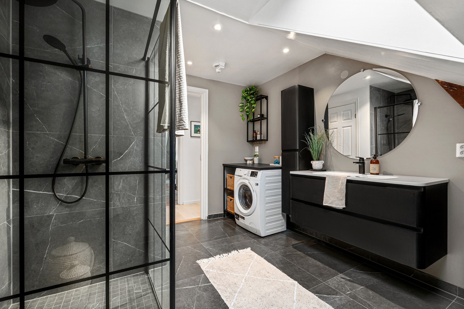 Baderommet oppleves som eksklusivt med sorte detaljer, lekre fliser og god oppbevaringsplass. Galleribilde