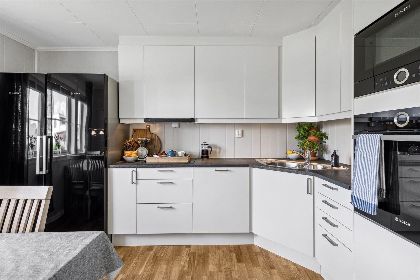 Det er montert praktisk benkebelysning under overskapene som gjør det enkelt å arbeide på kjøkkenet. Keramisk koketopp, komfyr, mikrobølgeovn og oppvaskmaskin er integrert i innredningen. Galleribilde