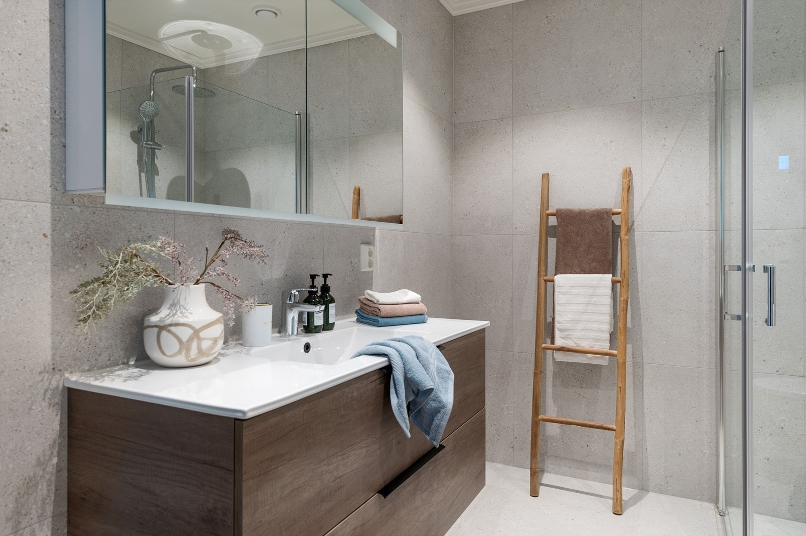 Boligens bad er flislagt på både vegger og gulv og har elektriske varmekabler som gir en behagelig temperatur. Rommet er innredet med nedfelt servant, toalett og dusjvegger/hjørne. Galleribilde