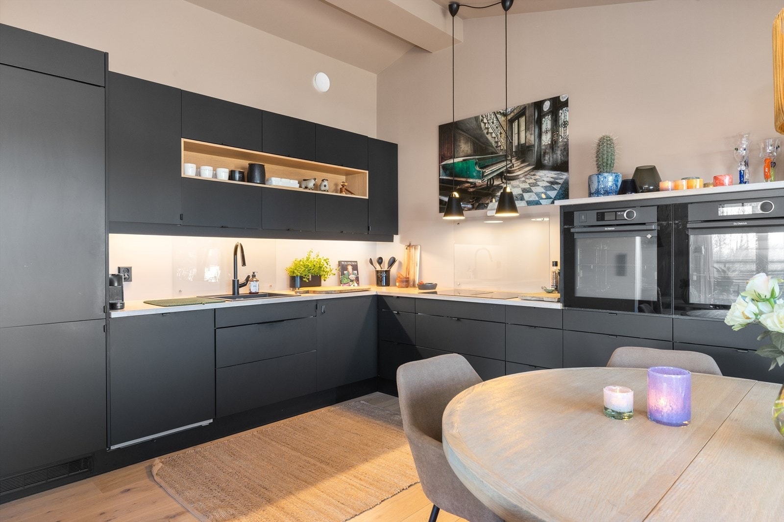 Moderne innredning fra 2021 med glatte fronter, glassplate over oppvaskkum og platetopp og heltre benkeplate. Galleribilde