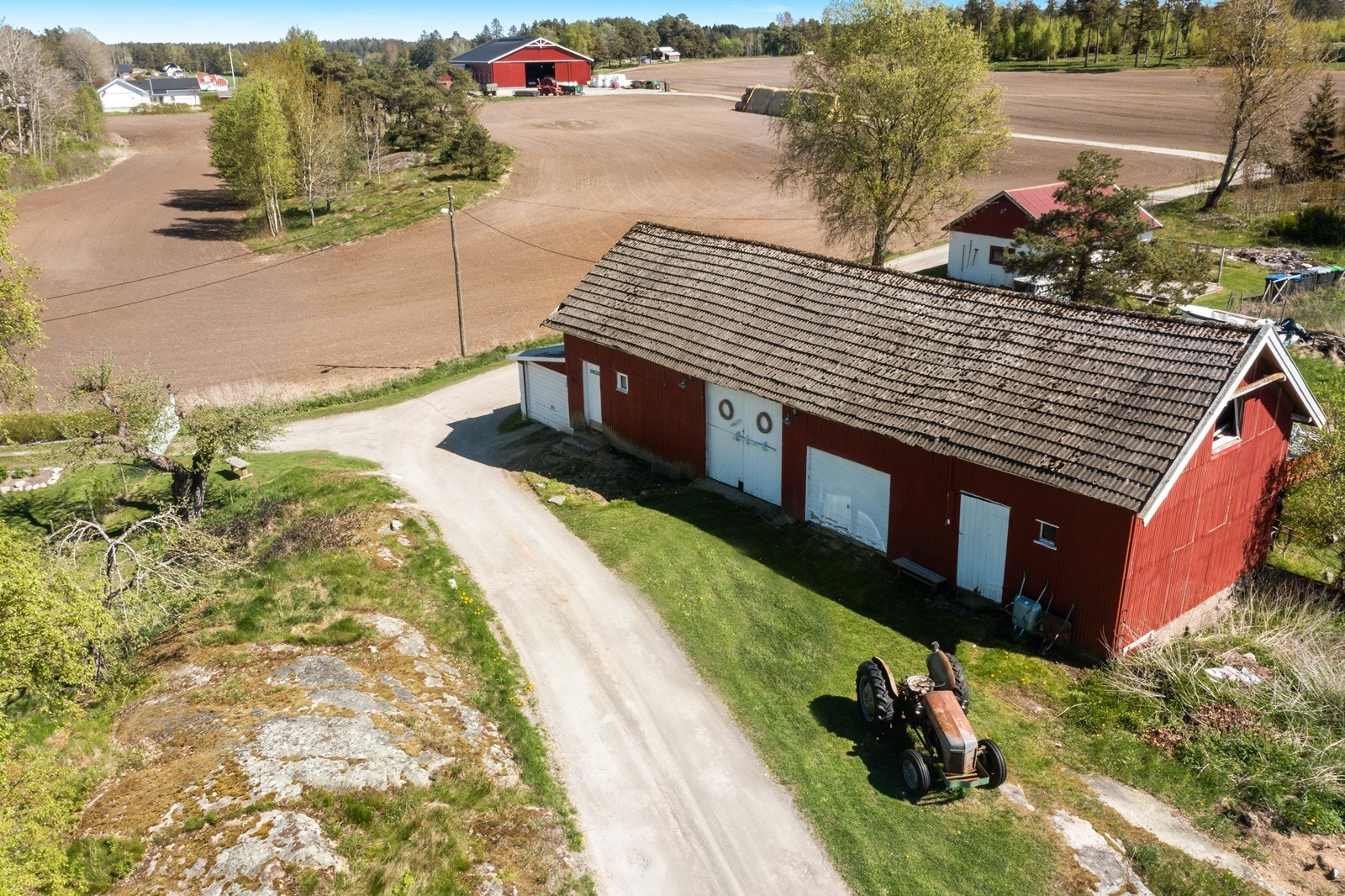 Låven er på 123 m2 og uthus/stall i bakgrunnen er på 45 m2 - Jordene i bakgrunnen er naboens Galleribilde