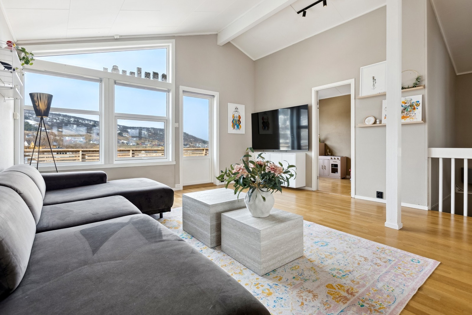 Stor og flott stue med skråtak, store utsiktsvinduer og utgang til utsiktsveranda. Galleribilde