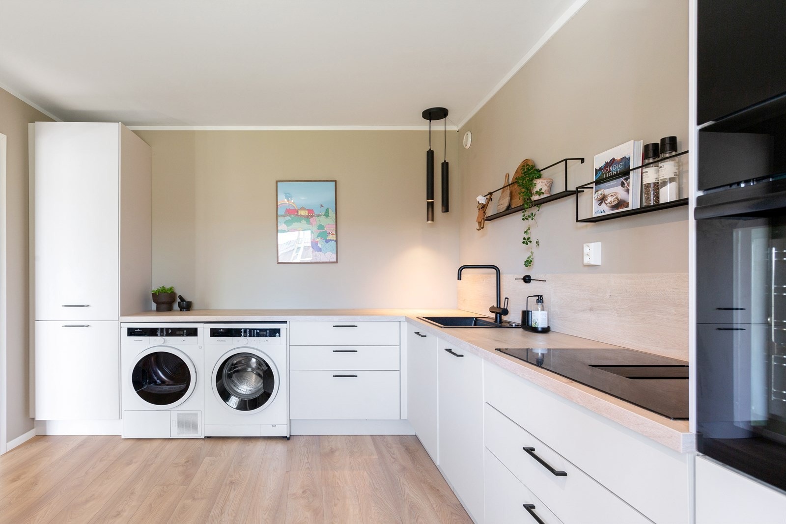 Vaskemaskin og tørketrommel har fått plass på kjøkkenet for å spare plass på badet - smart! Galleribilde