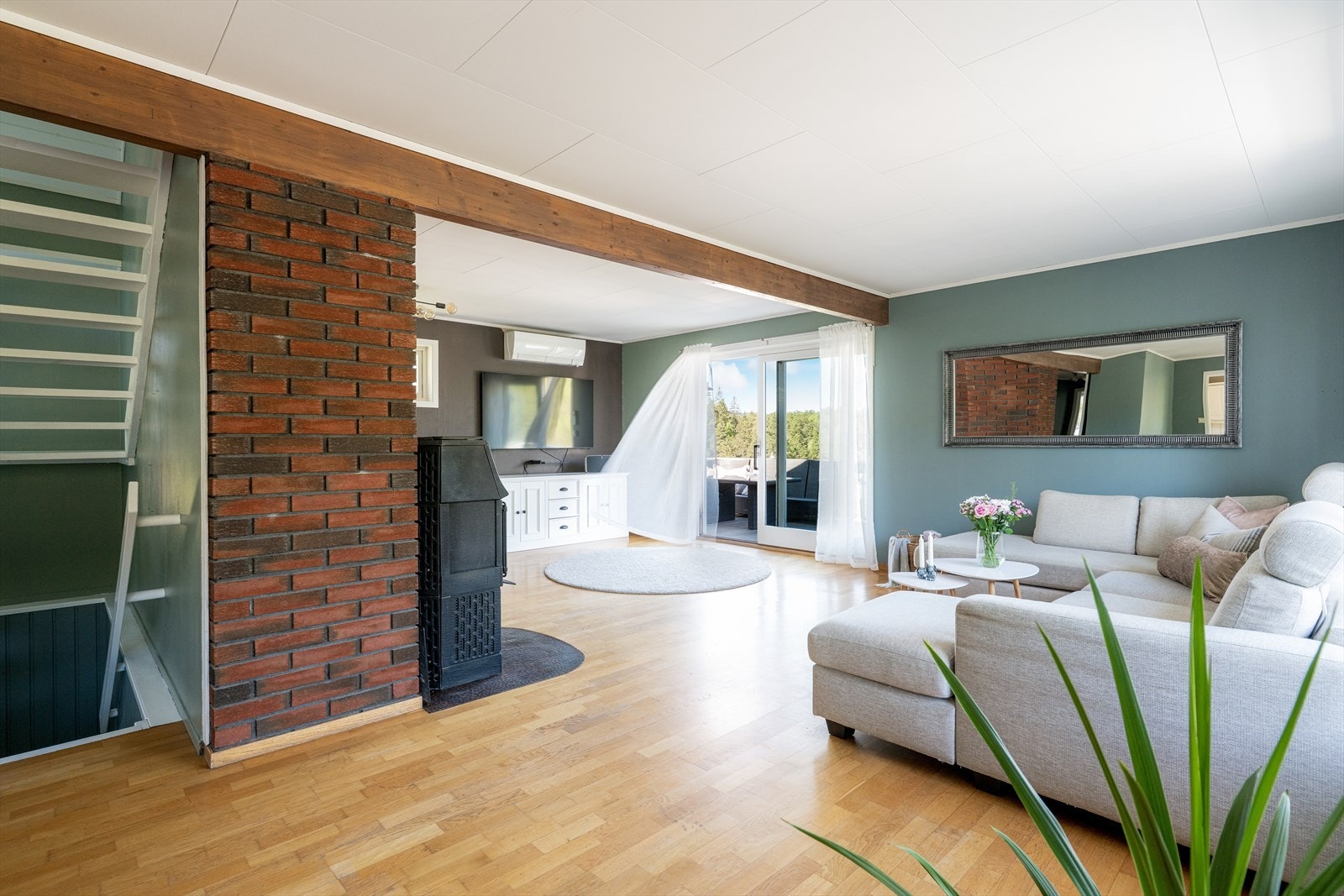 Store vindusflater på flere sider gir stua rikelig med dagslys og fint utsyn mot nærområdet. Galleribilde