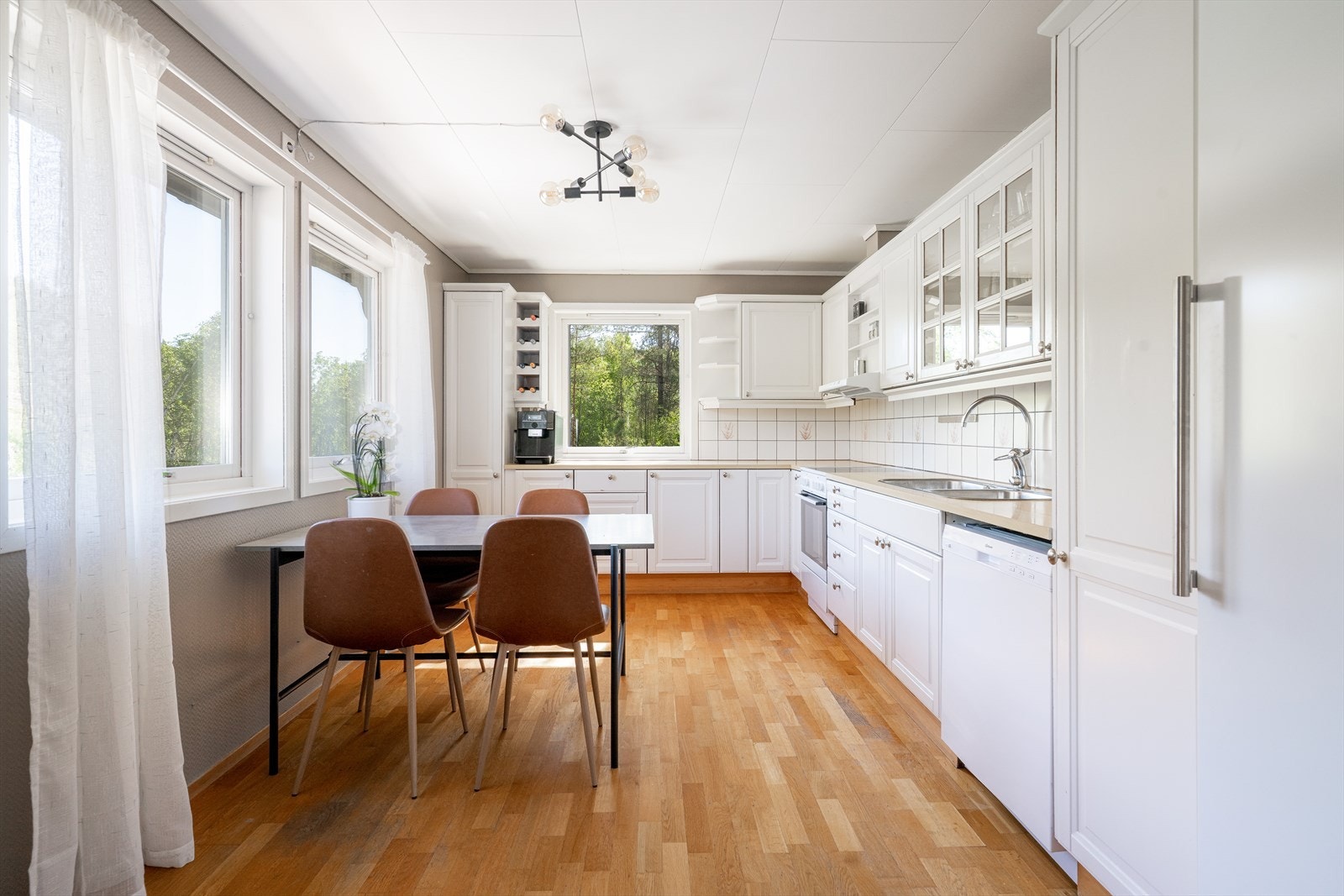 Det er godt med oppbevaringsplass i innredning fra byggeår med profilerte fronter og innslag av glass-skap og åpne hyller. Galleribilde