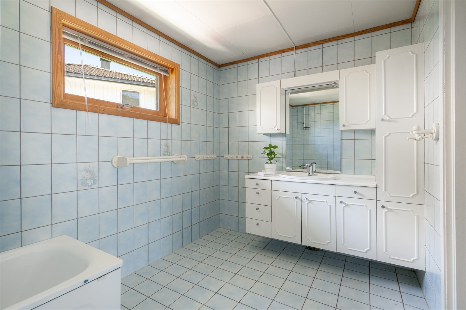 Badet på hovedplan fra byggeår er av god størrelse. Badet er helfliset med varmekabler på gulvet, og har servantskap med god oppbevaringsplass. Galleribilde