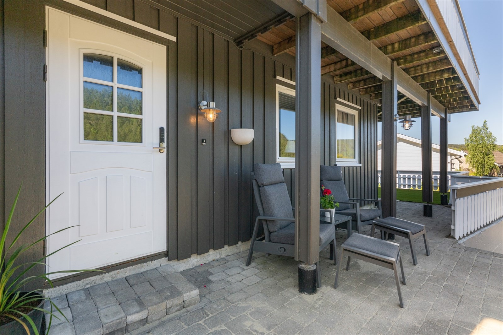 Fra asfaltert gårdsplass og garasje er det etablert trapp opp til det hyggelige, delvis overbygde inngangspartiet. Galleribilde