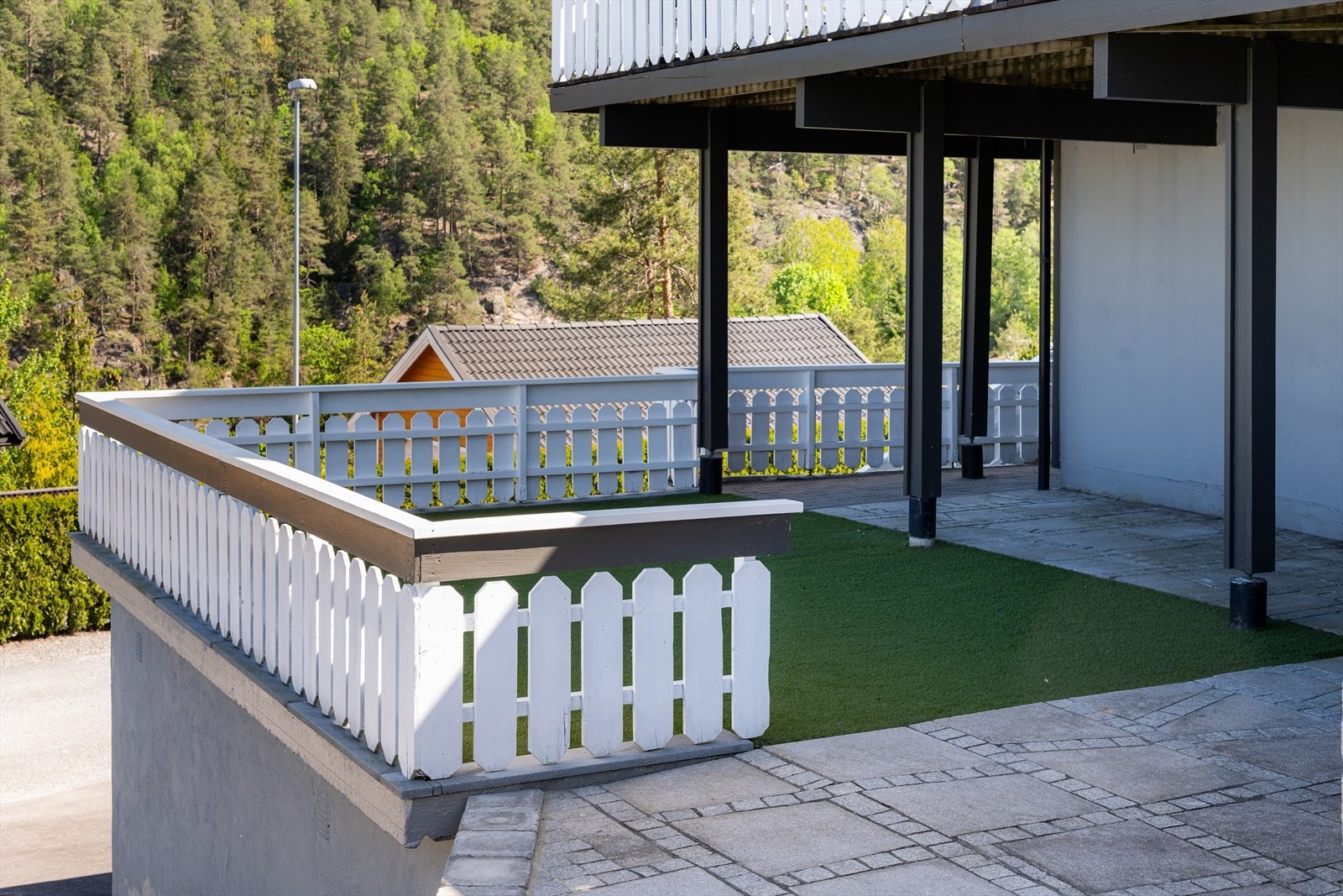 Her er det lagt belegningsstein som går videre rundt boligens fasade og opp mot hagedelen. Galleribilde