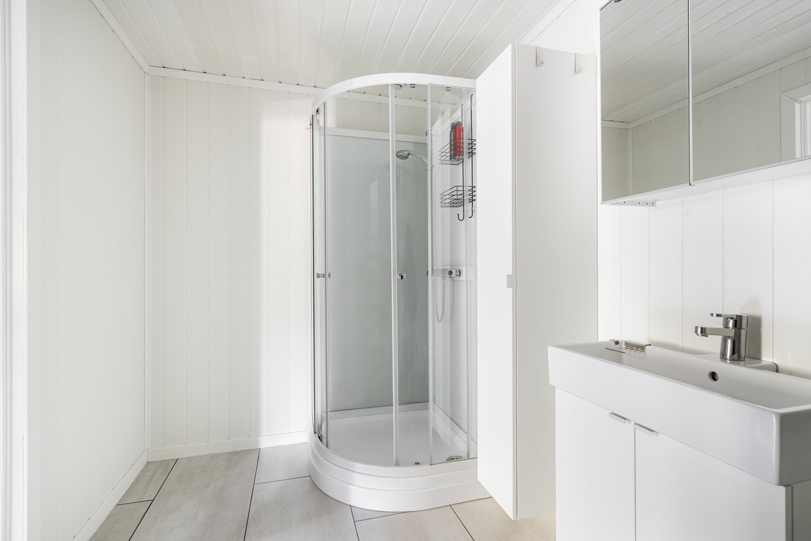 Badet har innredning med heldekkende servant, speilskap med overlys, høyskap, dusjkabinett og toalett. Interiør på badet er også fra 2019. Galleribilde