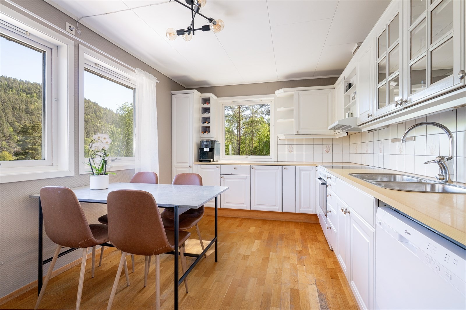 Gode arbeidsflater på laminerte benkeplater med dobbel nedfelt oppvaskkum, og flis under overskapene. Galleribilde