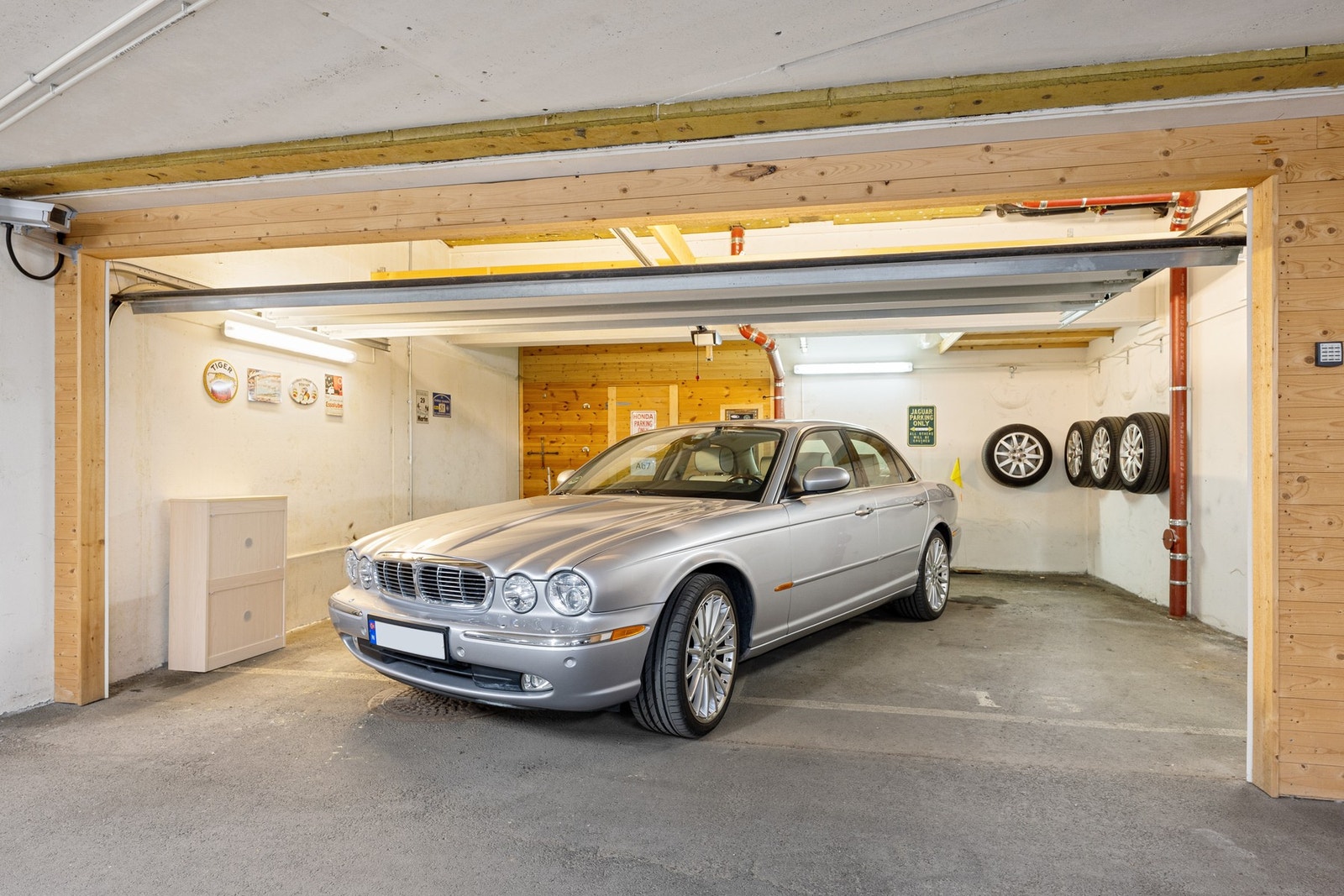 Det tilhører en adskilt dobbel garasje med bod i felles parkeringskjeller Galleribilde