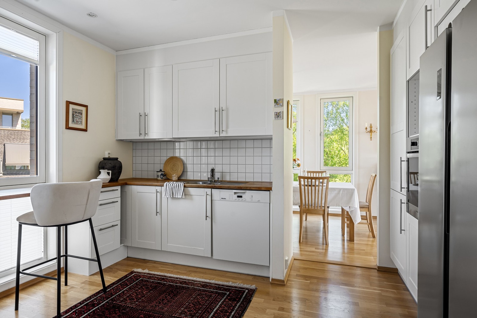 Separat kjøkken med stilren innredning og heltre benkeplate med oppvaskkum Galleribilde