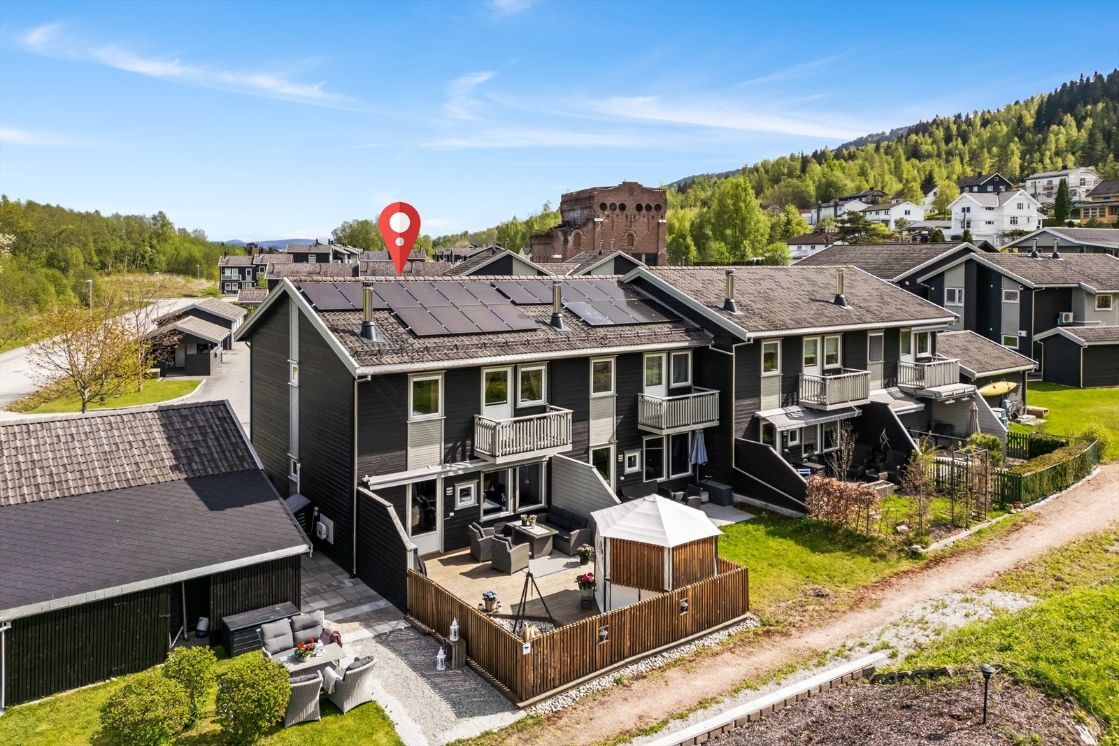 Fin intern beliggenhet med solrik uteplass. Det er terrasse både ved inngangsparti og på baksiden av boligen. Garasjeplassen er på siden. Galleribilde
