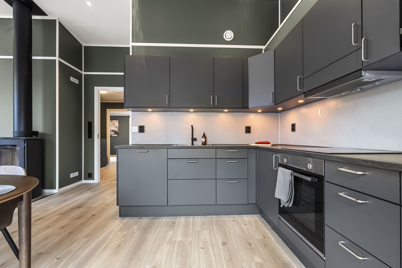 - På veggen over benkeplaten er det montert kitchen board. Spotter i underkant av overskapene - Galleribilde