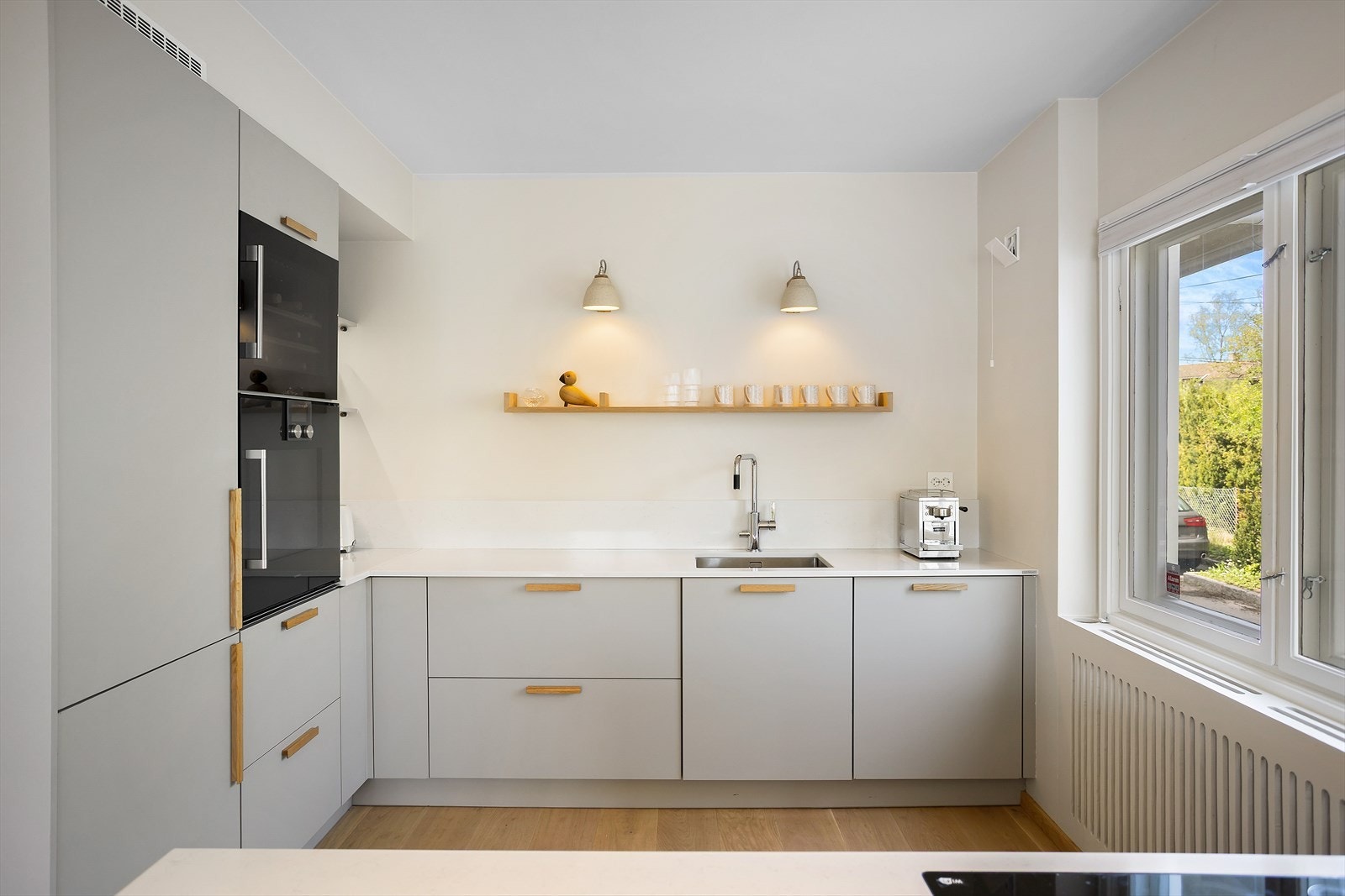 Kjøkkeninnredningen fra Impuls (2021) har slette fronter og en 20 mm tykk steinbenkeplate fra Steinriket med underlimt vaskekum i børstet stål. Galleribilde