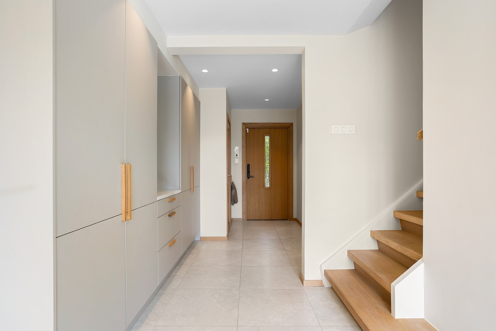 Lys og innbydende entré med flislagt gulv (60x60 cm) og behagelig gulvvarme. Veggene er malt i lyse farger, og taket har downlights. Galleribilde