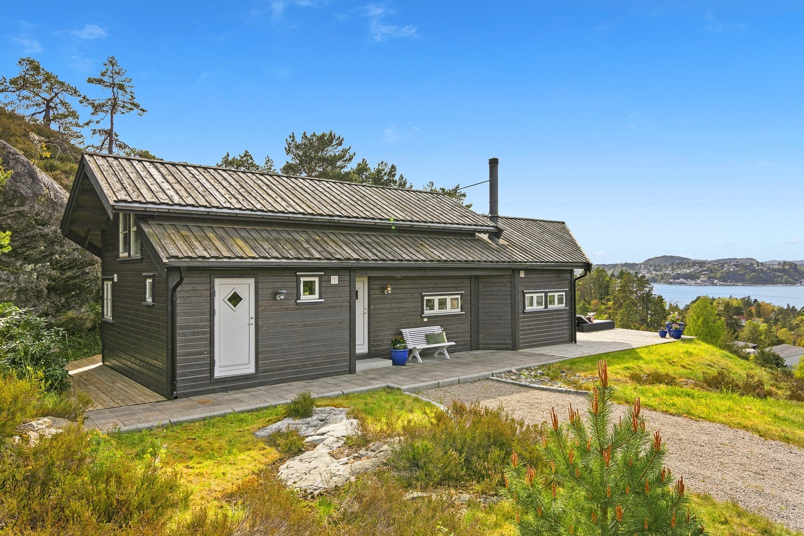 Tomten er opparbeidet med gruset adkomst og store terrasser i front. Galleribilde