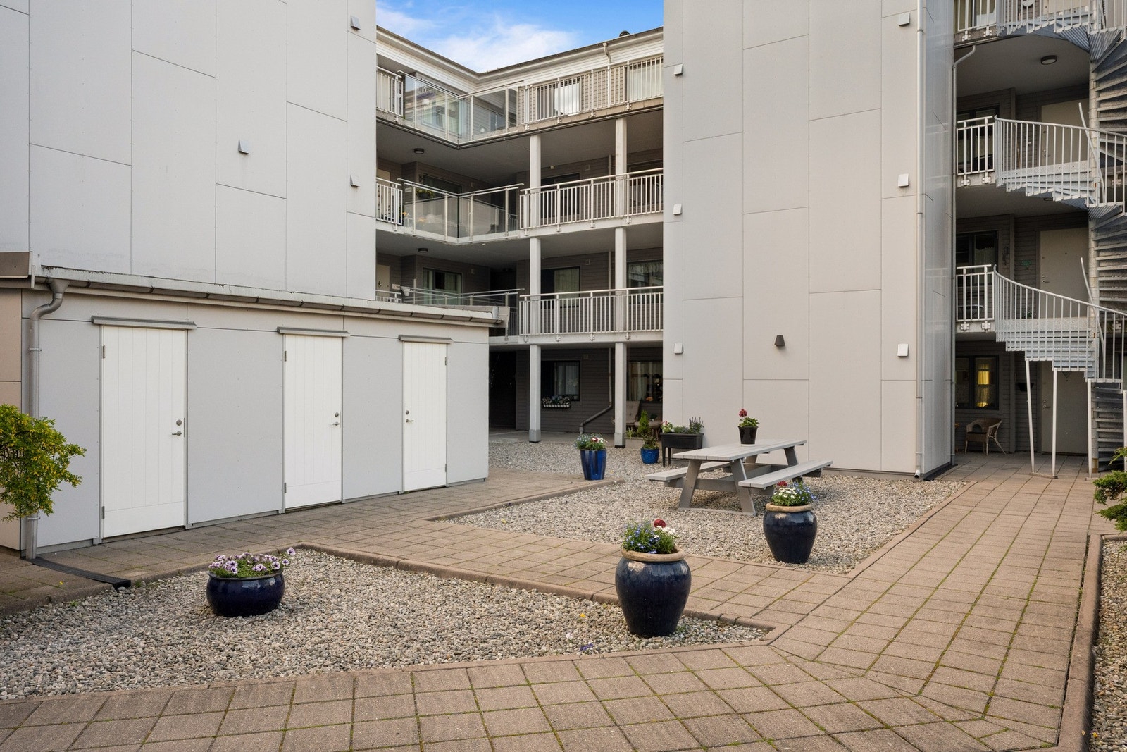 Det er hellelagte gangstier og partier med singel i bakgården, i tillegg til hyggelige sittegrupper Galleribilde