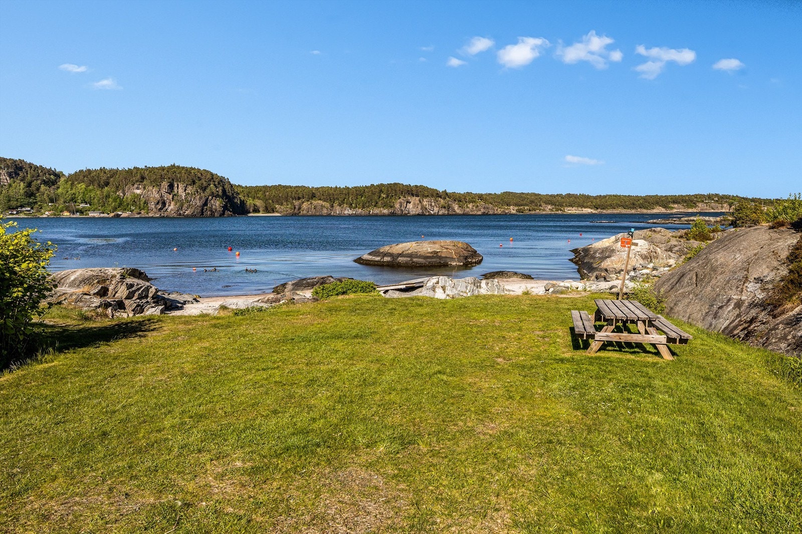 Ved sjøen rett nedenfor hytta er det fine badestrender, gressplen og svaberg. Her går også kyststien. Galleribilde