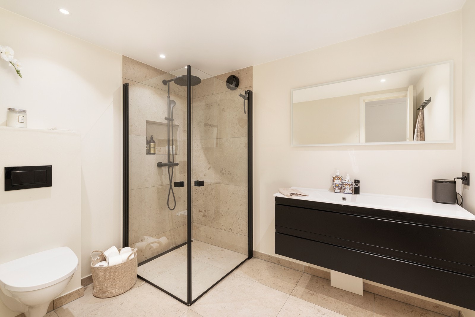 Lekkert bad med fliser på gulv og i dusjsone. Jotun våtroms system på vegger. Badet har videre vegghengt toalett og servant med underskuffer. Galleribilde