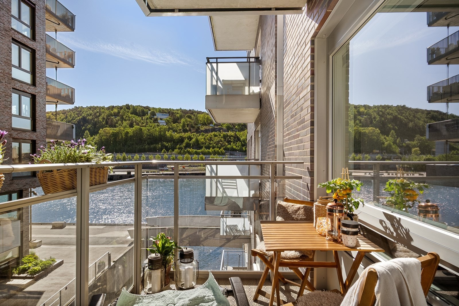 Balkongen er skjermet og solrik med nydelig utsikt mot vannspeil og grønne åssider. Galleribilde