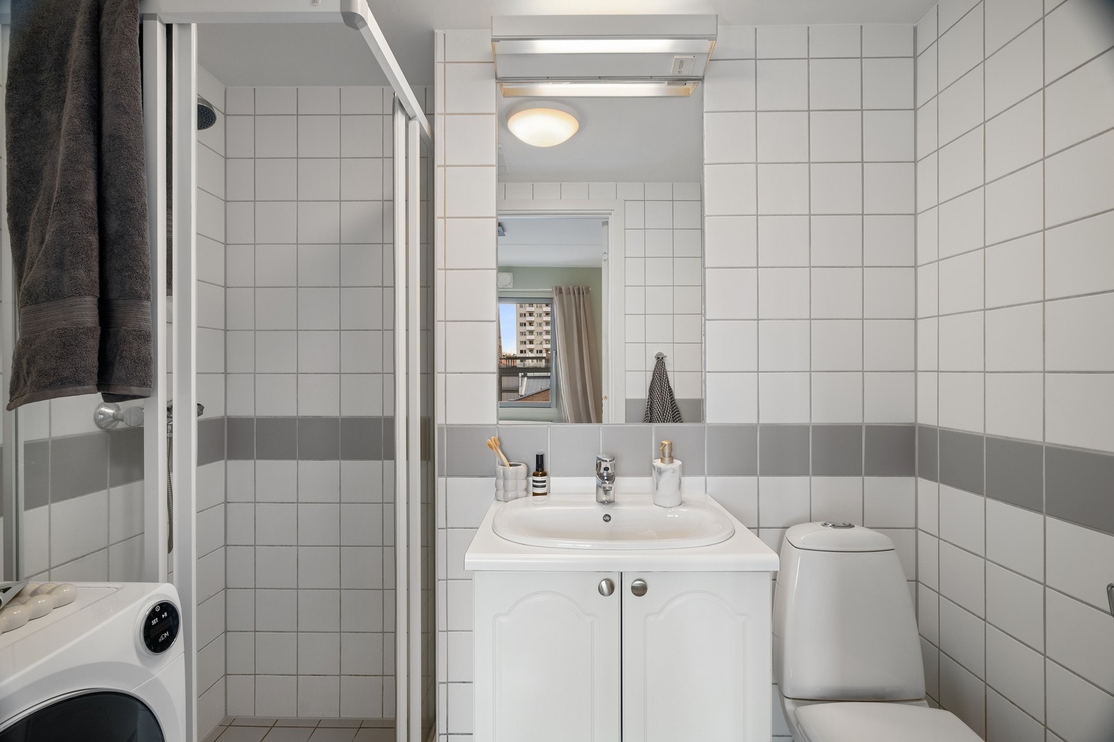 Flislagt baderom med vaskemaskin. Galleribilde